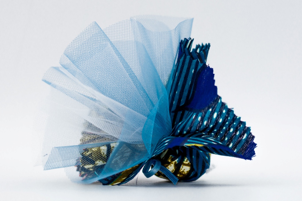 stoffa colorata blu e azzurra da Tanzania tipo Kitenge, con dentro confetti e tulle a mò di sacchettino, bomboniera solidale Africa