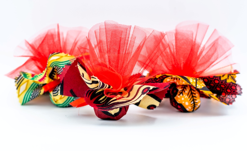 stoffe colorate colori assortiti da Tanzania tipo Kitenge, con dentro confetti e tulle a mò di sacchettino, bomboniera solidale Africa
