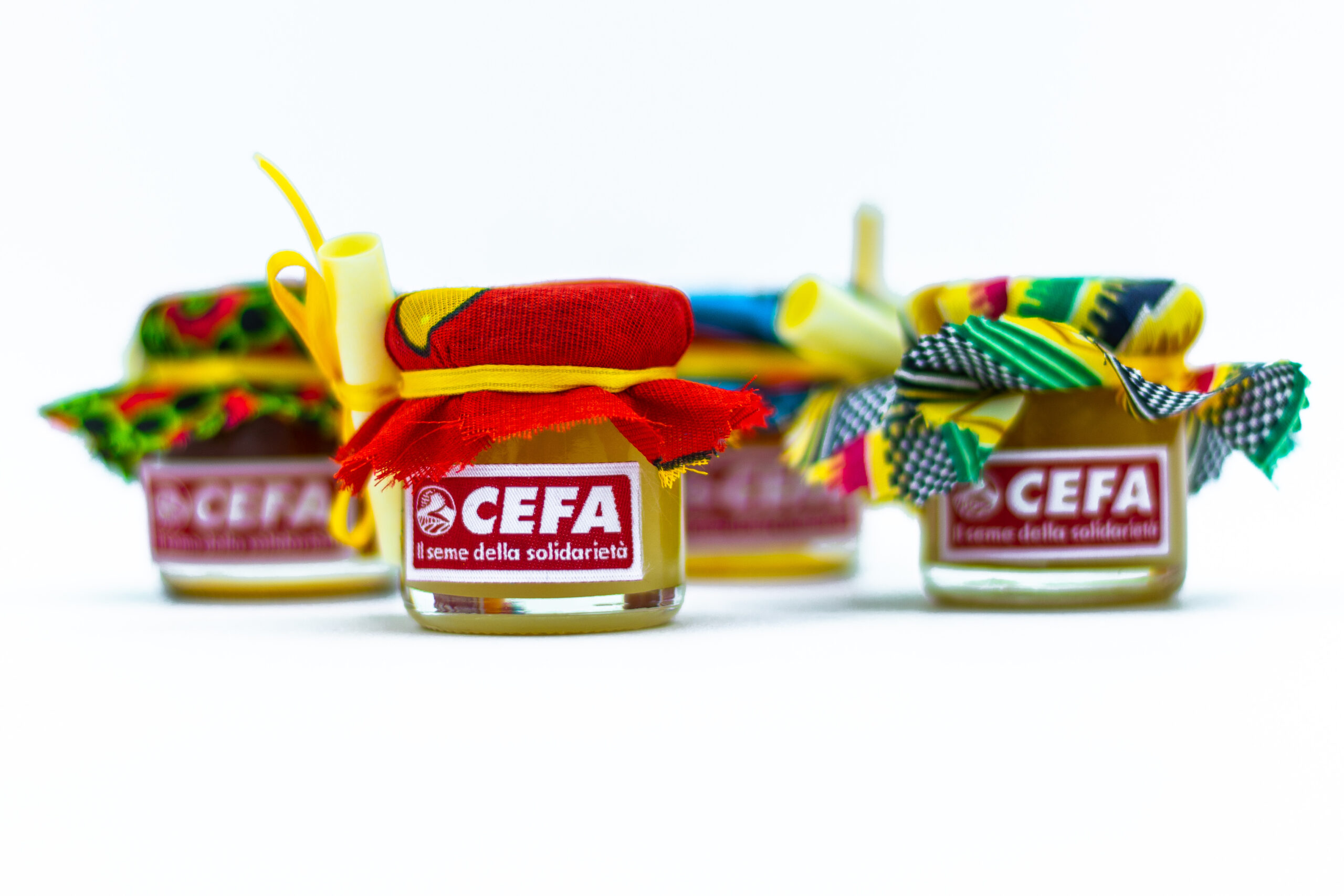 vasetti di miele con copricoperchio in stoffa africana, deliziose bomboniere solidali vivaci e buonissime. Colori e gusti di miele assortiti